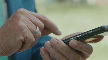 Hands of man in green area typing on smartphone video