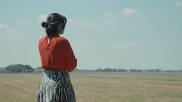 Woman standing in field calling with smartphone video