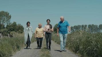 deux femmes un homme et une fille marchant et parlant dans la campagne video