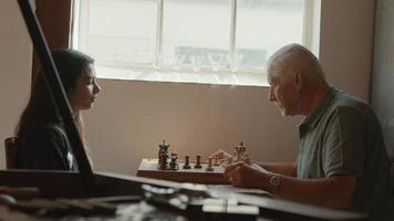 Mädchen und Mann spielen Schach am Tisch video