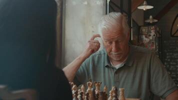 Girl and man playing chess at table video