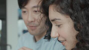 Woman and man having conversation whilst watching laptop video