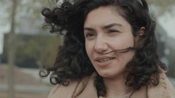 mujer con cabello ondeando al viento habla video