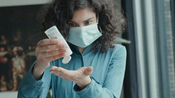 Frau mit Mundschutz desinfiziert die Hände video