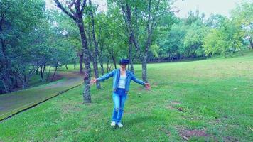 Happy woman wearing VR-headset glasses of virtual reality in forest and enjoying the nature on a sunny summer day in spring garden. Modern technology concept. video