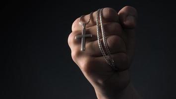 Close-up images of crucifix pendant and necklace in hand photo