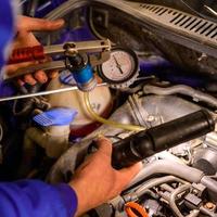 Professional car mechanic working in a car service, computer diagnostics of the bonnet space in the car. photo