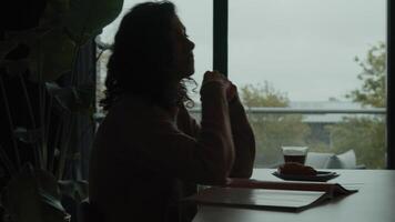 Woman talks and reads magazine at breakfast table video