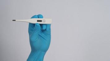 Hand holding digital thermometer photo