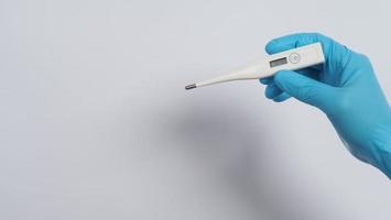 Hand holding digital thermometer photo