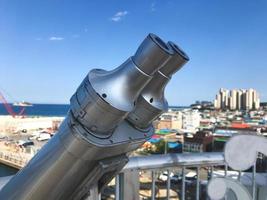 Observation binoculars on the bridge and Sokcho city on the background, South Korea photo