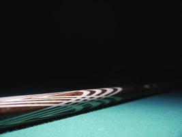Billiard cue on a table. Close-up. Black background photo