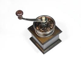 The wooden coffee grinder with coffee beans on white background. The view from above photo