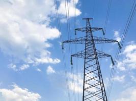 The power line. High voltage pole and blue sky on the background. Bottom view photo