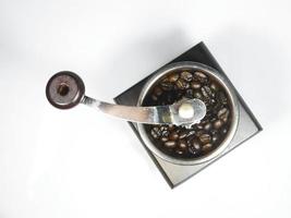 The wooden coffee grinder with coffee beans on white background. The view from above photo