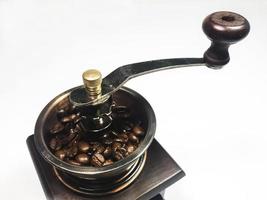 The wooden coffee grinder with coffee beans on white background. Close-up photo