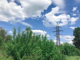 The power line. High voltage pole and blue sky on the background. Bottom view photo