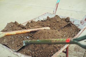 Closeup pile of soil on the steel shovels in the wheelbarrow photo