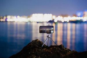 Using a smartphone on a tripod with long exposure of the sea at night photo