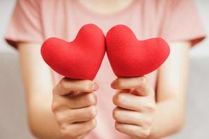 mujer sosteniendo un corazón rojo, amor, seguro médico, donación, feliz voluntario de caridad, día mundial de la salud mental, día mundial del corazón, día de san valentín foto