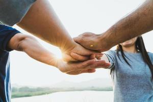 gente juntando sus manos. amigos con pila de manos mostrando unidad y trabajo en equipo. amistad, felicidad, ocio, asociación, equipo, concepto. foto