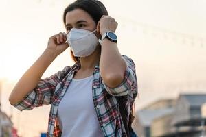 Asian woman wearing N95 mask to protect pollution PM2.5 and virus. COVID-19 Coronavirus and Air pollution pm2.5 concept. photo