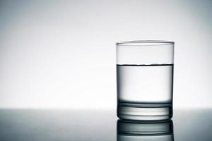 un vaso claro de agua fresca sobre la mesa. foto