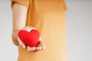 mujer sosteniendo un corazón rojo, amor, seguro médico, donación, feliz voluntario de caridad, día mundial de la salud mental, día mundial del corazón, día de san valentín foto