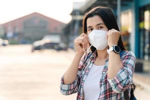 Asian woman wearing N95 mask to protect pollution PM2.5 and virus. COVID-19 Coronavirus and Air pollution pm2.5 concept. photo