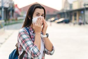 Asian woman wearing N95 mask to protect pollution PM2.5 and virus. COVID-19 Coronavirus and Air pollution pm2.5 concept. photo