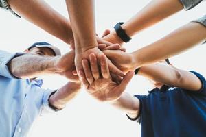 People putting their hands together. Friends with stack of hands showing unity and teamwork. Friendship happiness leisure partnership team concept. photo