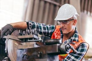 Engineer metalworker working on lathe machine photo