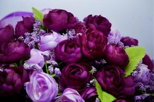 flores artificiales de color púrpura y rosa, hojas verdes sobre fondo blanco. flor de primavera, pascua, día de la mujer, día de la madre, concepto del 8 de marzo. copie el espacio.
