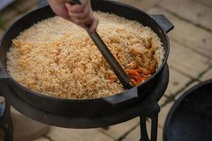 el proceso de cocinar pilaf. plato nacional de cocina oriental. foto