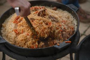 The process of cooking pilaf. National dish of oriental cuisine. photo