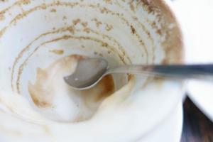 Taza blanca con sobras de café en la mesa foto