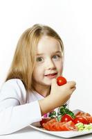 Cute little girl with plate of fresh vegetables photo