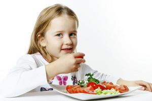 Cute little girl with plate of fresh vegetables photo