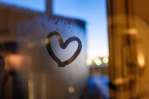 Drawing heart on window in winter photo