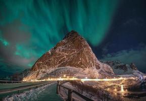 Aurora Borealis with star over snowy mountain in Reine at Lofoten Islands photo