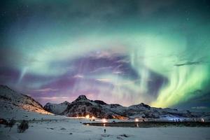 aurora boreal, explosión de la aurora boreal con estrellas en la montaña foto