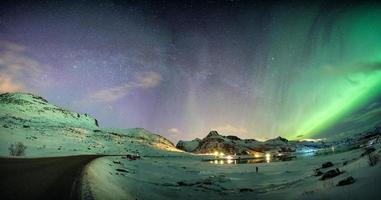 Aurora borealis with starry over mountain range on arctic coastline photo