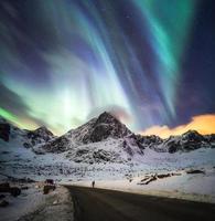 Aurora borealis, Northern lights explosion over snow mountain photo