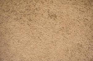 Weathered natural brown clay soil house wall background photo