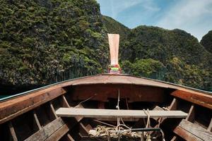 View from a traditional Thai wooden prow boat while floating in the bay provides a tourist with beautiful scenery of the Natural Marine landscape, both mountains and sea in Phi Phi Island. photo