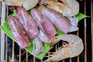 Los mariscos frescos como camarones, calamares y pescado se tuestan tradicionalmente con hojas de plátano envueltas sobre una parrilla de carbón ahumado. es una cena deliciosa para fiestas de barbacoa, picnics o comidas en restaurantes. foto