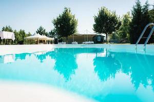 piscina azul al aire libre en el jardín rodeado de árboles