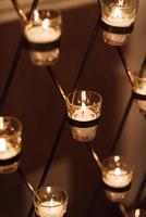 Candles burn in glasses on the wedding arch photo