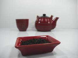 té chino y una tetera roja con una taza en el bachground foto