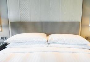 White pillows decoration on bed in bedroom interior photo